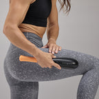 woman using purewave cmx massager on side of her leg
