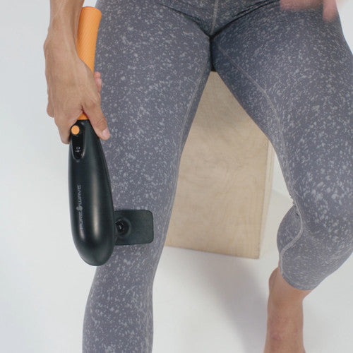 person using purewave cmx massager on her knees